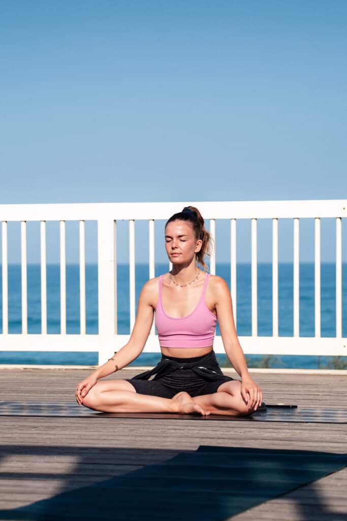 Professeur de yoga en posture du tailleur sur le toit de l'Espace de l'Océan à Anglet
