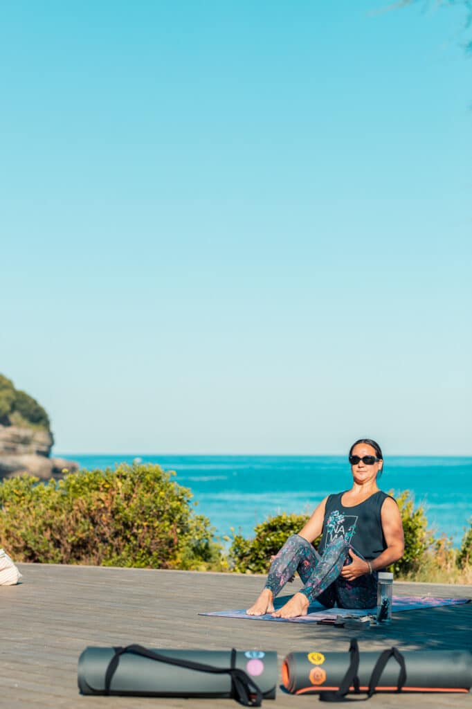 Professeur de yoga réalisant une posture sur le deck de la Chambre d'Amour à Anglet