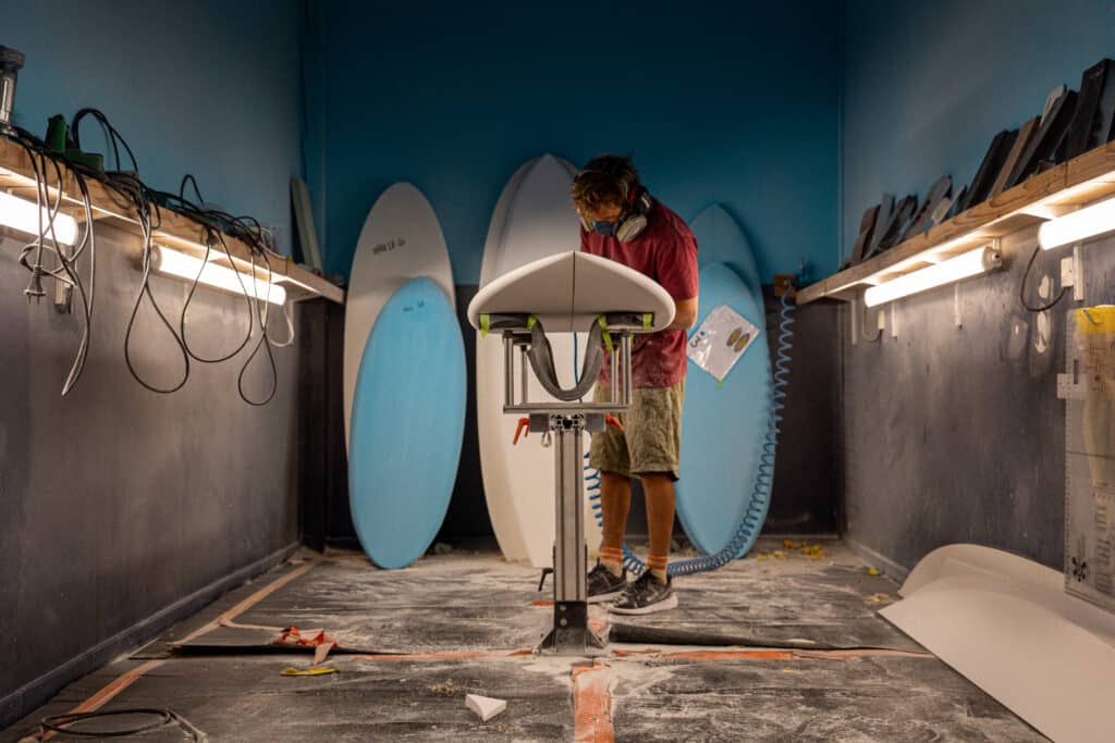 Shaper entrain de poncer une planche dans l'atelier NOTOX.
Crédit photo @dariotni