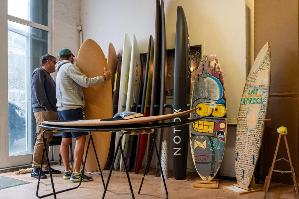 Surfeur entrain de choisir sa planche dans l'atelier NOTOX.
Crédit photo @dariotni
